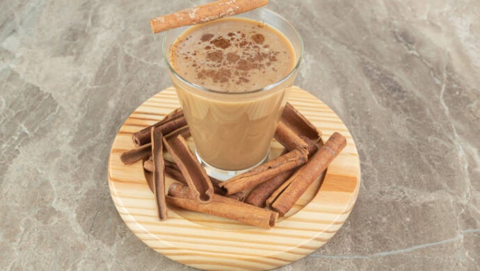 xícara de mochaccino canela com paus de canela ao lado