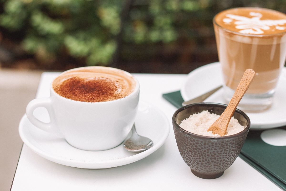 Xícaras e canecas de café em cápsulas sobre mesa de café da manhã