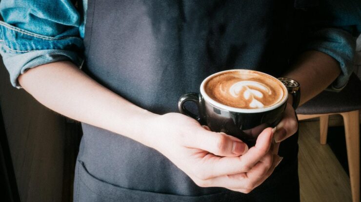 Barista segurando xícara de Café complexo espresso com leite