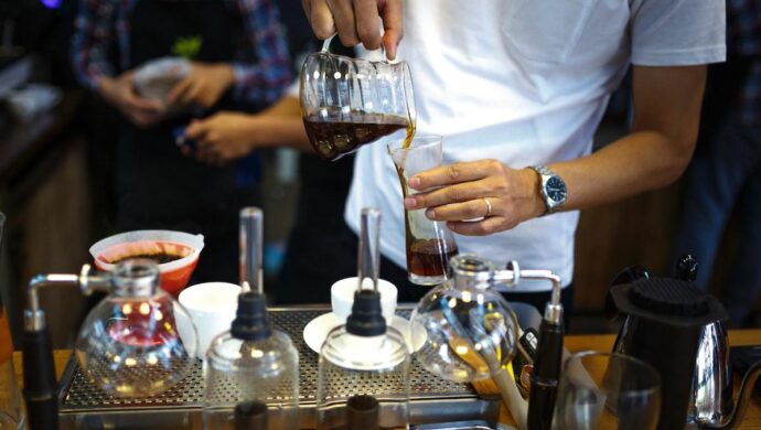 Barista preparando bebida Espress tonic à base de café em interior de cafeteria