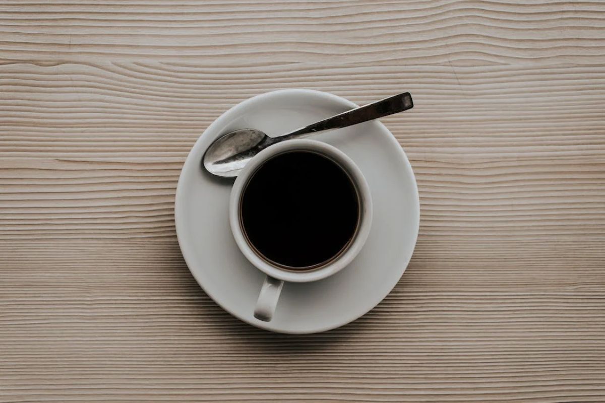 Xícara de café preto clássico sobre pires em mesa de madeira, preferência de um Apaixonado por café