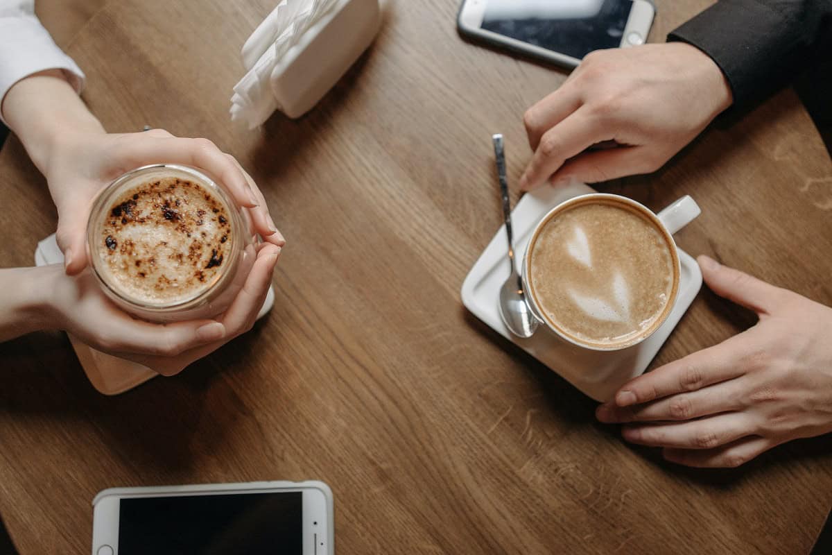 O Caf Com Baunilha A Combina o Perfeita two-men-sitting-in-a-cafe-talking-having-a-meeting-people-real