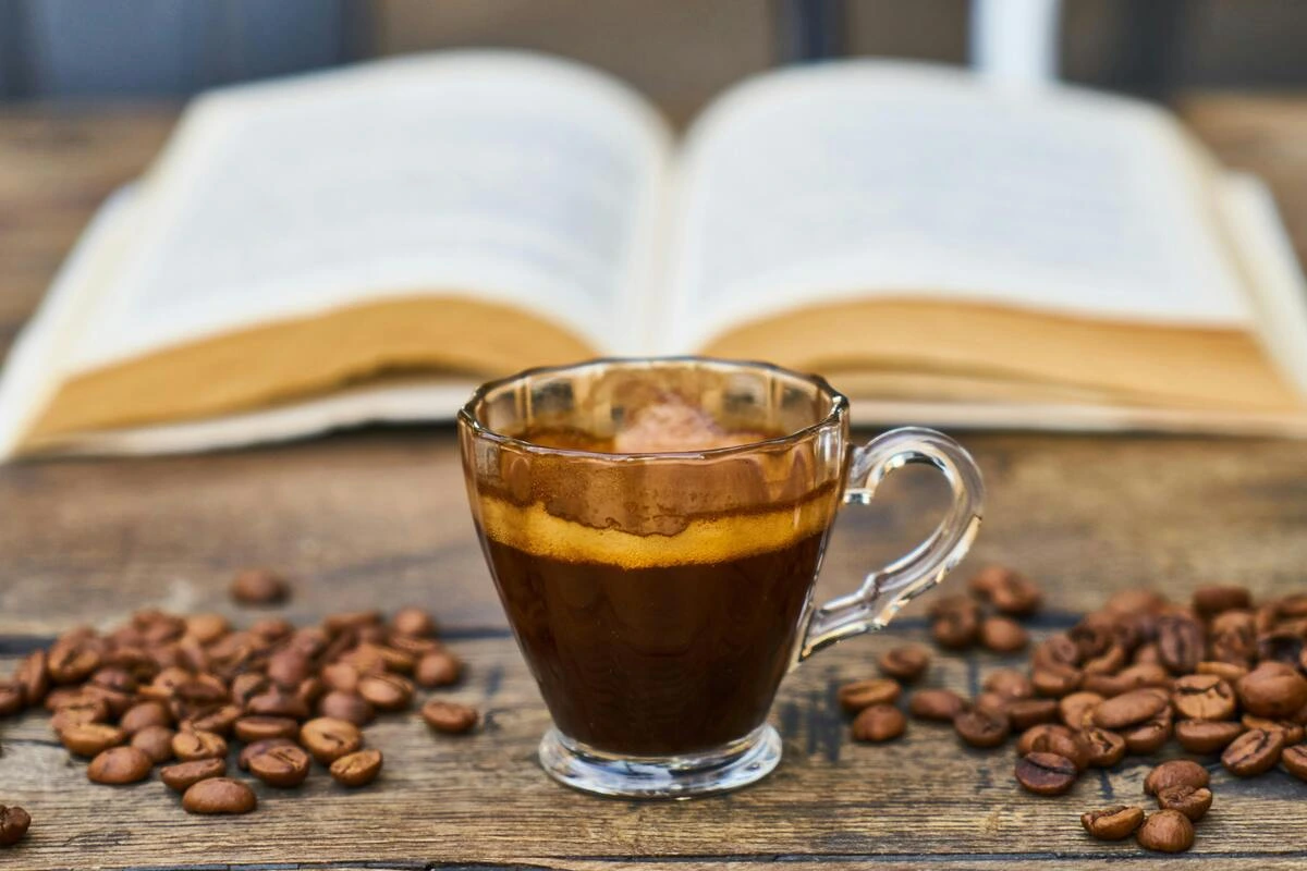 Xícara de café e livro em uma mesa.