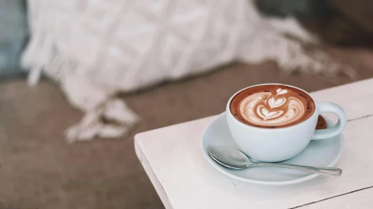 Xícara de café com um desenho feito com leite.
