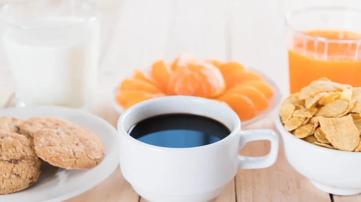 Imagem de um café da manhã equilibrado, com café preto, suco de laranja, biscoitos integrais, cereal e frutas, ideal para quem tem resistência à insulina.